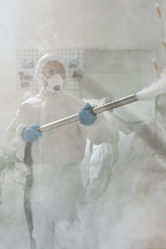 project-01-c A person in full protective gear fumigating a room to ensure sterilization against viruses.
